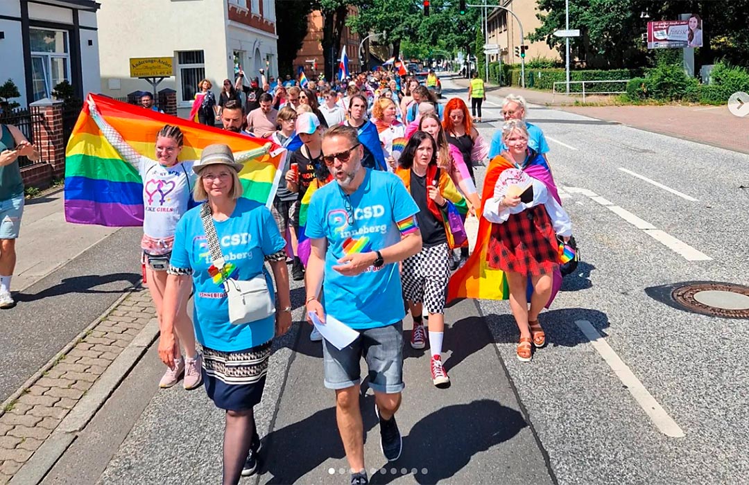 Menschen gehen beim CSD in Pinneberg auf der Straße